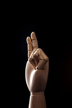 wood Mannequin, hand on the black background. 