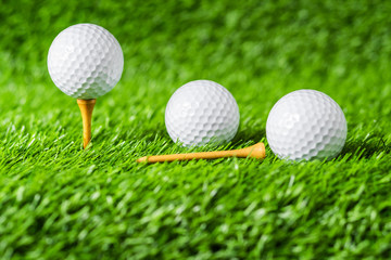 Golf ball with green grass background, on tee closeup.
