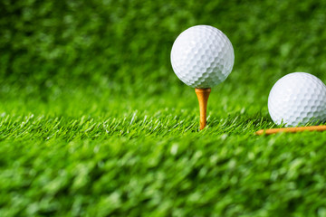 Golf ball with green grass background, on tee closeup.