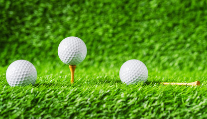 Golf ball with green grass background, on tee closeup.