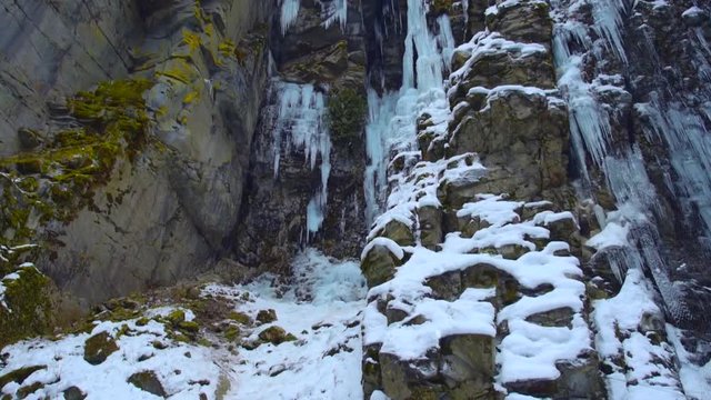 A winter setting in a canyon with frozen icicles.