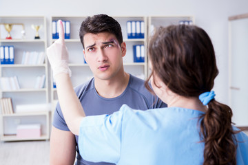 Obraz premium Young man visiting female traumatologist with black eye 