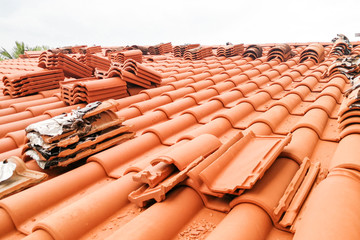 Old moldy roof tile being replaced with new tiles