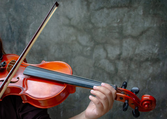 Closeup photo of Violinist playing the violin. The classical musician photo with dark background.