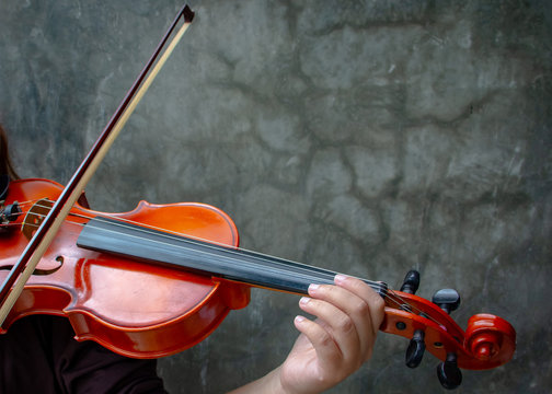 Closeup photo of Violinist playing the violin. The classical musician photo with dark background.