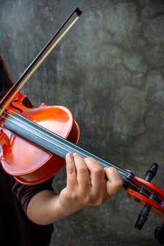 Closeup photo of Violinist playing the violin. The classical musician photo with dark background.