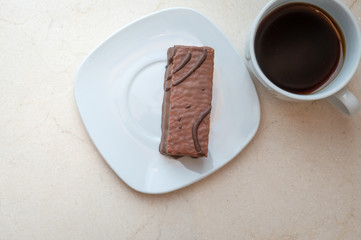 Little chocolate cake and a coffee cup on a flat lay image