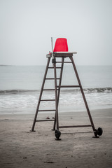 Life guard red chair on the beach on a rainy day