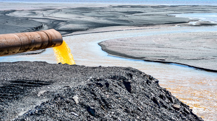 The industrial wastewater is discharged from the pipe into the water