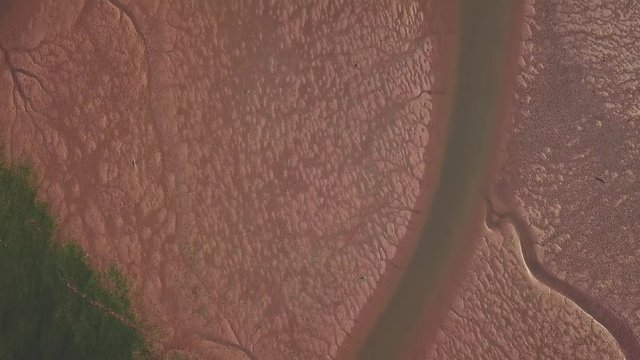 Flying over different depth of water in Lympstone England. Sand and water grass is very visible. The streams look like veins.