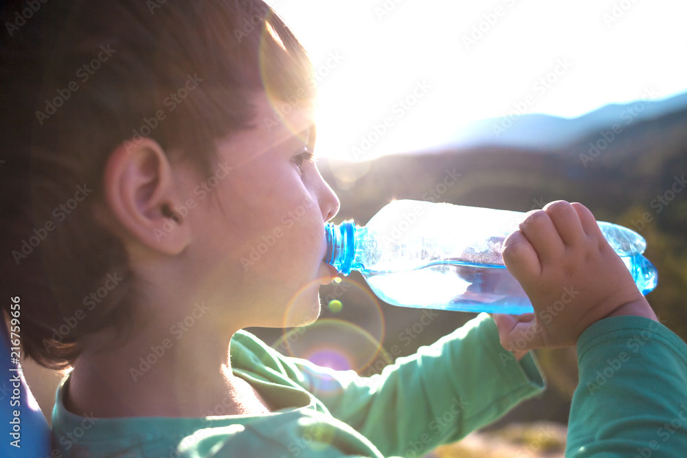 Wall mural a boy drinks water from a bottle.