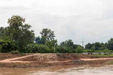 Fototapeta na wymiar View of the eroded riverbank road.