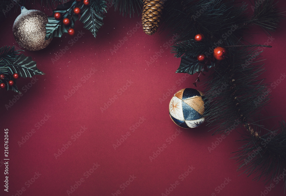 Poster christmas ball and fir branches for wreath with cherry and pine cone on red table background. winter