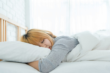 Fototapeta premium Beautiful young Asian woman sleeping in bed in the morning. Attractive asian girl use bedtime in her comfortable bedroom. Relaxation bedroom. Iifestyle asia woman at home concept.