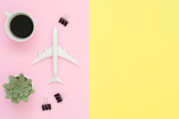 Flat lay design of travel in summer concept - Top view of plane, plant tree and coffee cup on blank pink yellow pastel color screen with copy space. travel on summer trip on pastel color background.