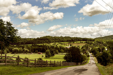 Fototapeta na wymiar Beautiful day on a country road that runs through farm land. 
