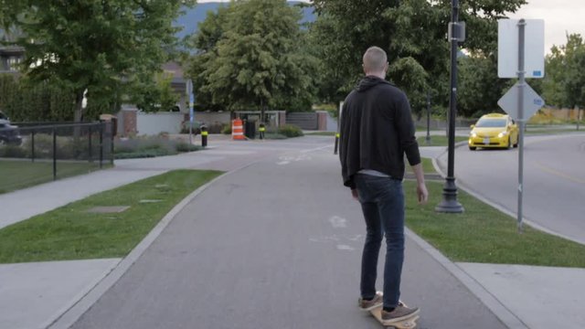 Slow Motion Man Longboarding Along Path By Street
