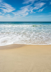 Fototapeta na wymiar Waves breaking on beach with blue sky - Port Elizabeth, South Africa