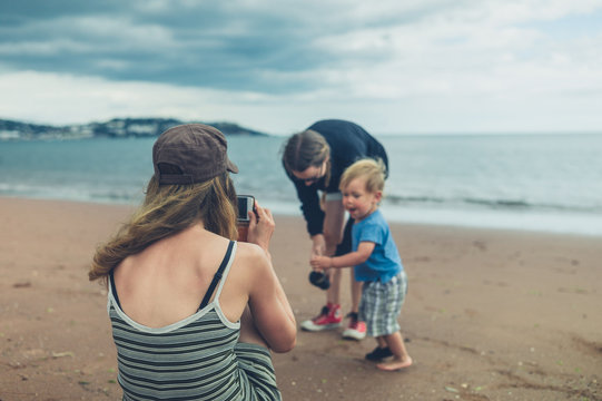 Two women and a toddler are having fun on the beach