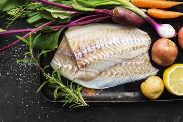 Cod. Fresh sea white raw fish before cooking in a with fresh vegetables: carrots, beets, celery,...