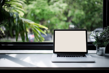 Laptop on white table in a cafe shop
