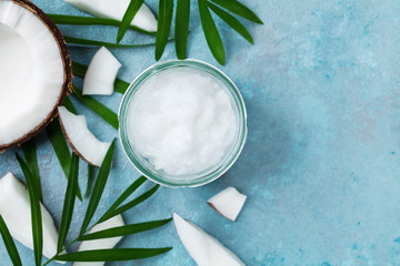 Organic coconut oil in jar and coconut fruit top view. Spa cosmetic and food ingredient. Flat lay. © juliasudnitskaya