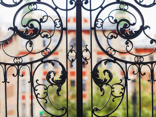 Fototapeta na wymiar Black vintage forged gates in Europe city.