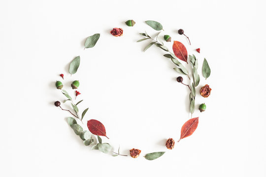Autumn composition. Wreath made of eucalyptus branches, rose flowers, dried leaves on white background. Autumn, fall concept. Flat lay, top view, copy space
