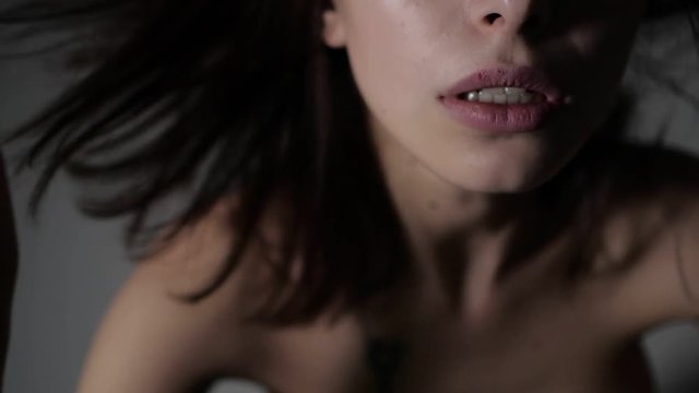 Nude brunette is touching up her hair