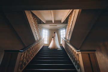 bride and groom on steps of a spiral staircase