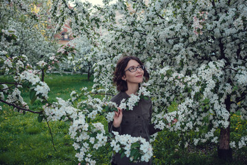 A young pregnant woman in an apple orchard in the heart of Warsaw.