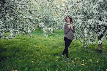 A young pregnant woman in an apple orchard in the heart of Warsaw.