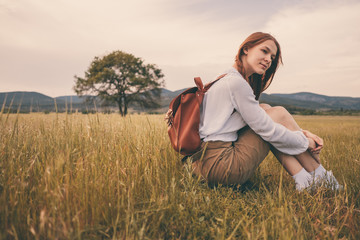 woman traveler with backpack and hat walking