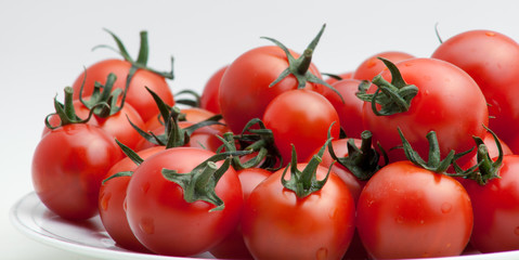 fresh tomatoes with green leaves isolated on white background