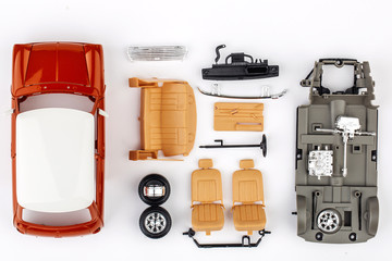 kit for assembling gray plastic car model on white background