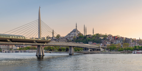 Fototapeta premium Golden Horn Metro Bridge (Halic Bridge) overlapping Suleymaniye Mosque before sunset, Istanbul, Turkey