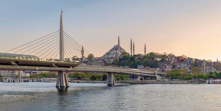 Golden Horn Metro Bridge (Halic Bridge) overlapping Suleymaniye Mosque before sunset, Istanbul, Turkey
