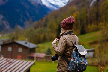 Beautiful girl photographer taking photos in the Swiss mountains. Switzerland.