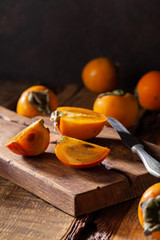 Fresh ripe persimmon on a wooden cutting board