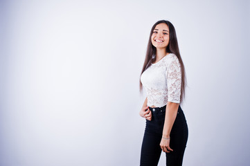 Portrait of an elegant young woman in white top and black pants in the studio.