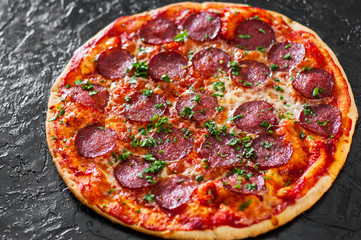 Pepperoni Pizza with Mozzarella cheese, salami, Tomatoes, pepper, Spices and Fresh Basil. Italian pizza