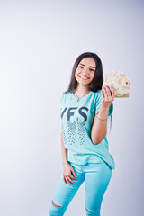 Portrait of an attractive girl in blue or turquoise t-shirt and trousers posing with a lot of money in her hand.