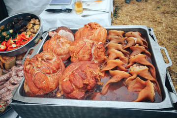 Outdoor grilled food. Smoked ham and ears. Festival of street food and meat.
