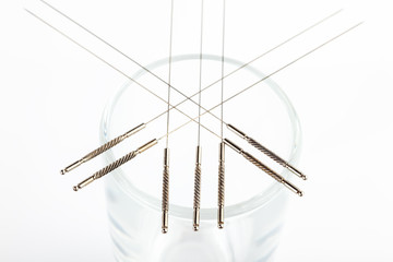 Silver needles for traditional Chinese medicine acupuncture. Close-up. White background.