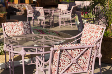 outdoor café, beautiful tables and armchairs, palm tree and flower bed, early morning