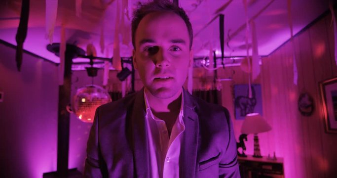 Point of view of drugged or drunk person having a man talk to them with a pink glow to the room