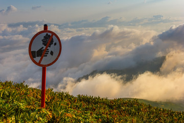 Warning symbol about herb and flora at the top of the mountain at sunset high in the mountains of Sochi, Russia, 08/22/2017
