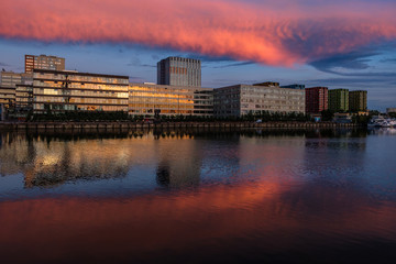 View of modern buildings near the water during sunset.
