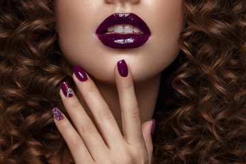 Beautiful girl with evening make-up, purple lips, curls and design manicure nails. beauty face....