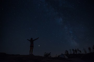 Young woman enjoying starry night on mountain trail